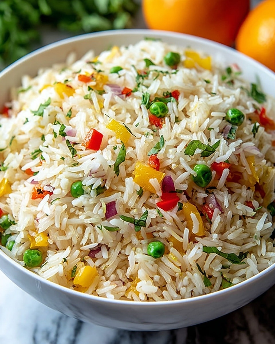 A close-up view of a white bowl filled with cooked rice mixed with small green peas, diced red onions, yellow bell peppers, and red bell peppers, all evenly spread throughout the rice. The rice grains are fluffy and white, with some pieces showing light browning. Small bits of green herbs are scattered across the dish, adding a fresh touch. The bowl is placed on a white marbled texture, and the background shows blurred hint of oranges and green leaves. photo taken with an iphone --ar 4:5 --v 7