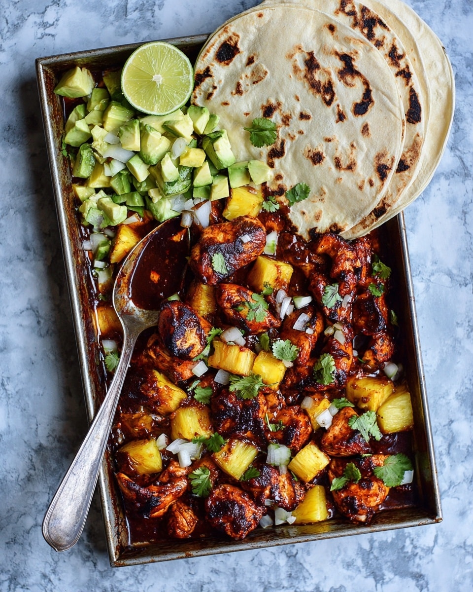 The image shows a metal baking tray filled with cooked chicken pieces mixed with chunks of bright yellow pineapple, all coated in a rich, dark reddish-brown sauce with some charred spots. On the top left side, there is a pile of light green chopped avocado and two lime wedges, one cut in half and placed beside a stack of three soft, light beige tortillas with brown grill marks, overlapping in a fan shape. The dish is garnished with scattered small pieces of white onion and green cilantro leaves. A silver spoon rests diagonally inside the tray on the left side. The tray is placed on a white marbled texture surface. Photo taken with an iphone --ar 4:5 --v 7