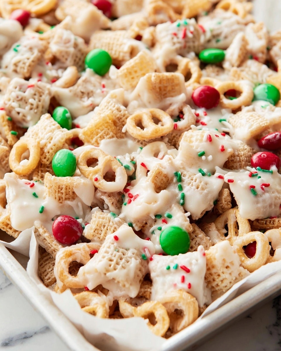 A white bowl filled with a mix of snacks covered in a glossy white coating, showing a variety of textures and colors in two layers: the base layer contains light beige square cereal pieces and creamy-colored ring cereals, while the top layer has twisted brown pretzels, bright red and green candy pieces, small light green popcorn, and tiny red, green, and white round sprinkles scattered all over. The mix looks sticky and glossy with the coating linking all pieces together. The bowl is on a white marbled surface with a blurred background of a flat tray filled with the same snack mix and a soft checkered cloth nearby. photo taken with an iphone --ar 4:5 --v 7