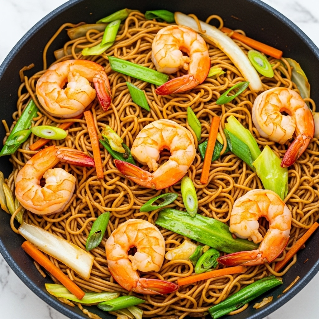 A close-up view of a pan filled with shrimp stir-fried noodles, showing several large, bright orange cooked shrimp spaced evenly on top. The shrimp rest on a tangle of thin brown noodles mixed with chopped green onions, light green cabbage pieces, and thin orange carrot sticks. All ingredients have a slight glossy shine from the sauce coating them, and the pan has a black interior. The image background is a white marbled texture. photo taken with an iphone --ar 4:5 --v 7