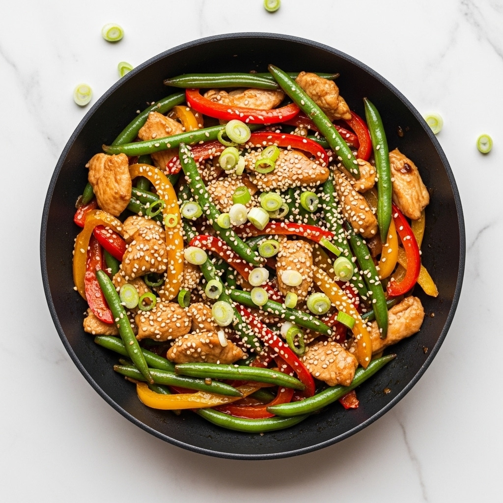 A black cast iron pan filled with a colorful stir-fry dish showing three main layers: a base layer of cooked chicken pieces in light brown, tender and slightly glossy; mixed with bright red and yellow bell pepper slices, soft and shiny; green beans spread evenly throughout, adding fresh green color; topped with thinly sliced green onions scattered on top, adding freshness and contrast; small white sesame seeds sprinkled lightly across the dish enhancing texture. The pan sits on a white marbled surface with blurred fresh vegetables in the background. Photo taken with an iphone --ar 4:5 --v 7