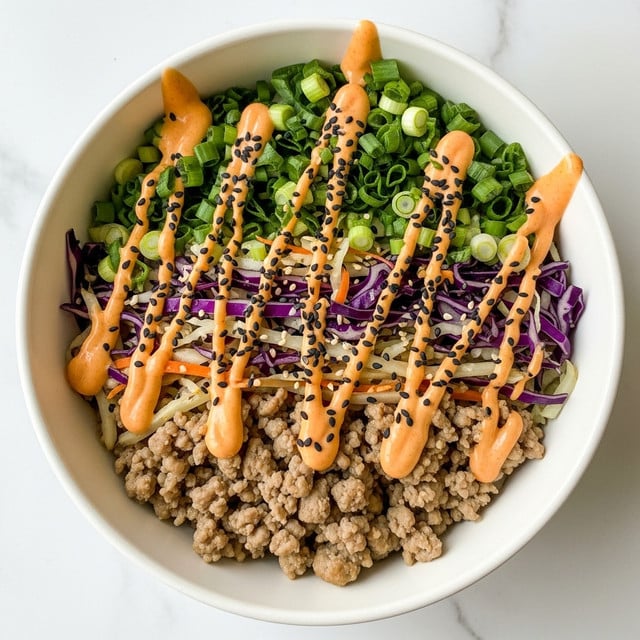 A white bowl filled with a colorful dish having roughly three layers: the bottom layer contains cooked ground meat with light brown color, mixed with chopped vegetables including white and purple cabbage with crunchy texture and deep purple and pale yellow shades. On top, there is a bright orange creamy sauce drizzled in diagonal lines, sprinkled with black sesame seeds and chopped fresh green onions adding a fresh green color contrast. The bowl is placed on a white marbled surface, creating a clean and bright setting. photo taken with an iphone --ar 4:5 --v 7