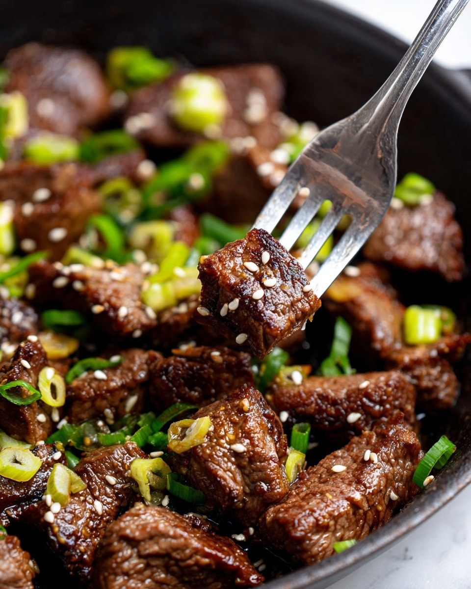 A close-up view of small pieces of cooked beef with a dark brown, slightly crispy outside, mixed with light green sliced scallions and sprinkled with small white sesame seeds. The beef pieces have a shiny, oily texture, and are cooked in a black skillet. A fork is holding one piece of beef in the middle, showing its juicy texture. The background is a white marbled texture. photo taken with an iphone --ar 4:5 --v 7