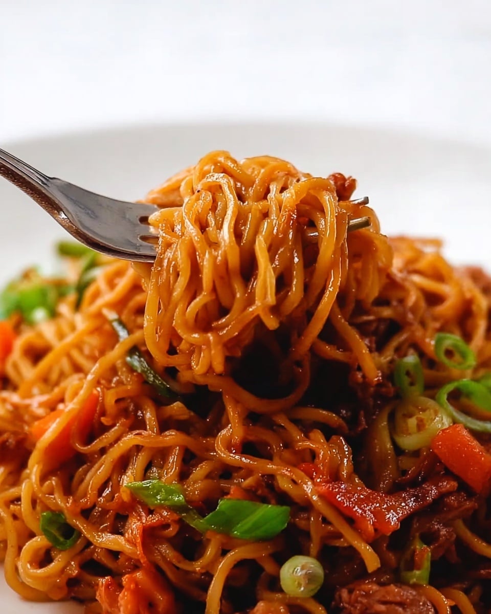 A close-up of a fork lifting a tangled bunch of glossy, golden-brown noodles mixed with small pieces of cooked reddish-orange vegetables and bits of tender brown meat; the background shows more noodles and green chopped scallions scattered around, all on a white plate sitting on a white marbled surface. Photo taken with an iphone --ar 4:5 --v 7