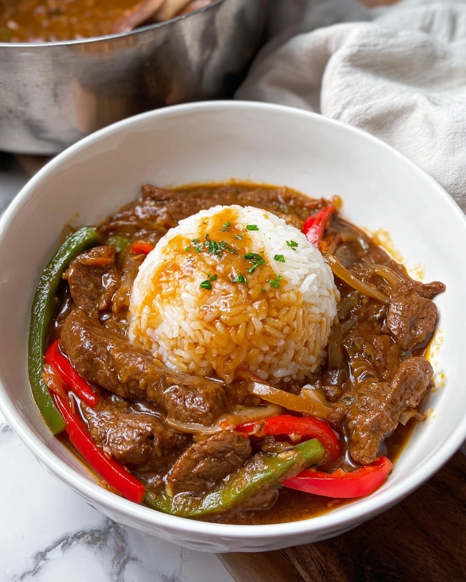 The dish shows a white bowl filled with three main layers: at the center is a dome of white rice with a glossy brown gravy sauce lightly covering the top and sprinkled with small green herb pieces; surrounding the rice is a thick mix of brown beef strips and sautéed onions, along with red and green bell pepper slices, all coated in the same brown sauce which gives a shiny and slightly textured look; the bowl sits on a white marbled surface with part of a stainless steel pot and white cloth nearby. photo taken with an iphone --ar 4:5 --v 7