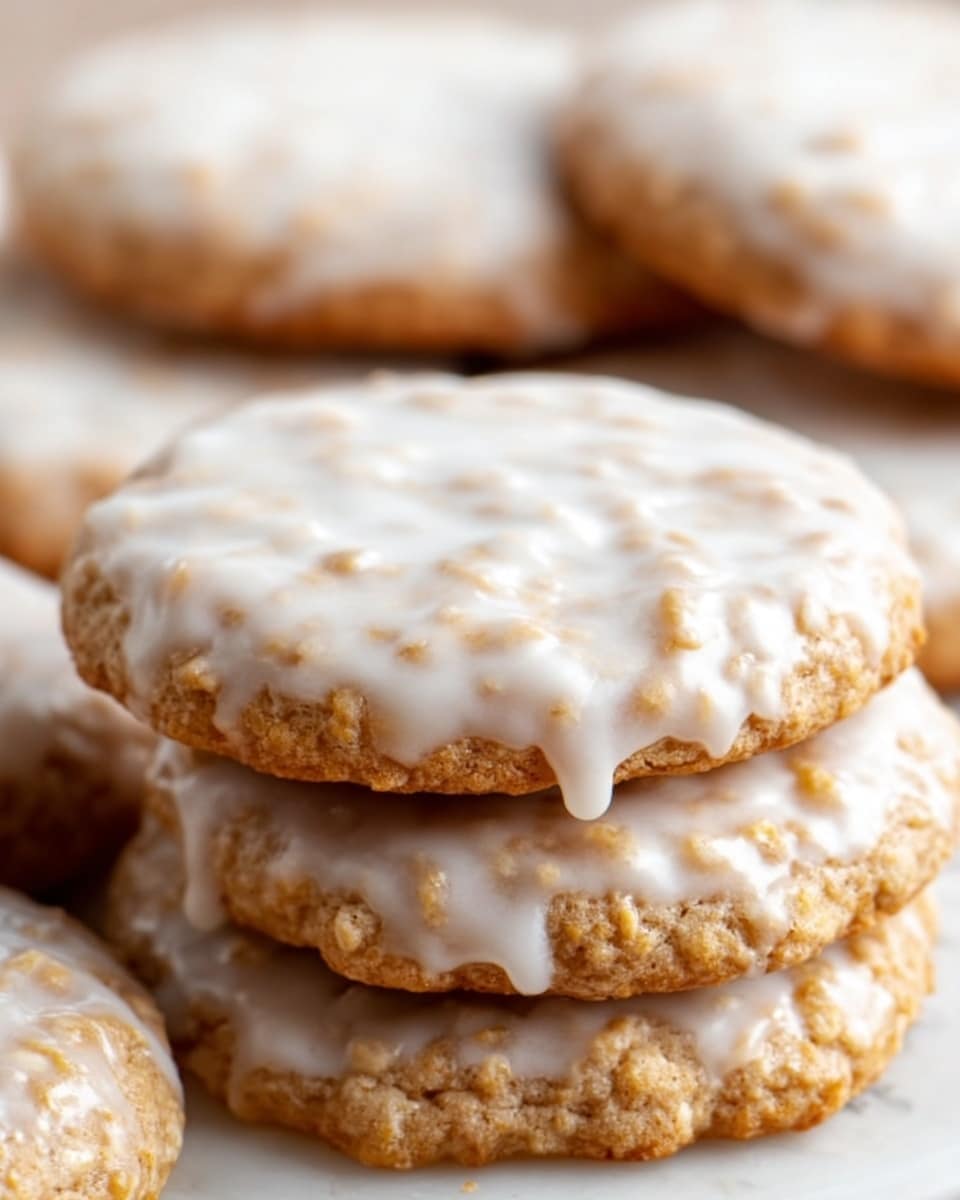 A close-up view of eight round cookies stacked on a white plate, each cookie covered with a smooth, light white icing that slightly drips over the edges. The cookies are light brown with visible oats embedded in them, giving a rough texture beneath the shiny glaze. The cookies vary slightly in size, with some stacked on top of others, creating a soft pile. The background shows a soft blurred white marbled texture with hints of warm light, giving a cozy feel. Photo taken with an iphone --ar 4:5 --v 7