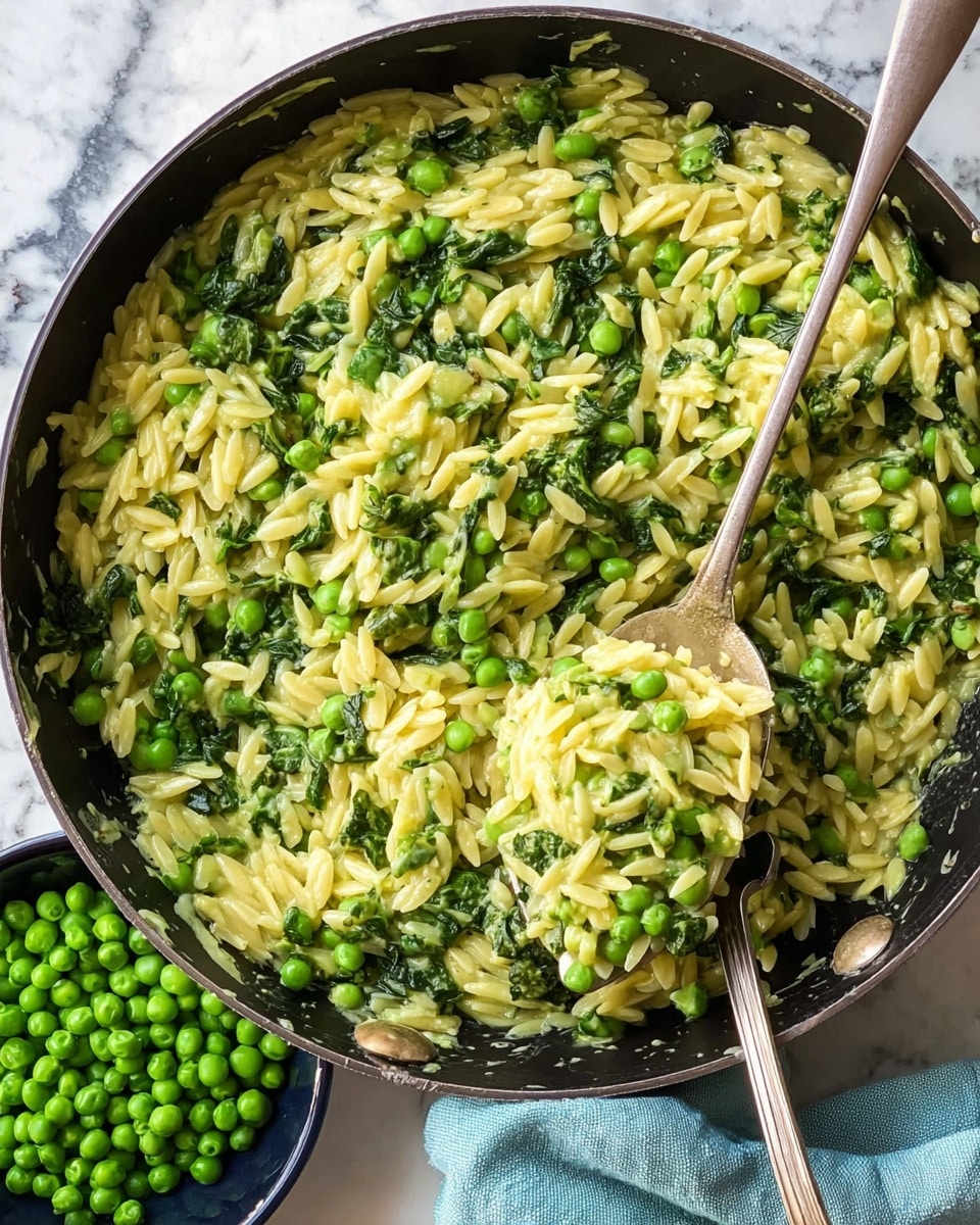 A black skillet filled with creamy risotto layered with vibrant green peas and fresh spinach leaves. The risotto is pale yellow with a soft, creamy texture, speckled with fresh green herbs scattered evenly on top. Small dots of black pepper and bright lemon zest are sprinkled across the surface, adding color contrast. Around the skillet, there is a portion of hard cheese on the white marbled surface, along with a yellow lemon squeezer and fresh green herbs in the background. photo taken with an iphone --ar 4:5 --v 7