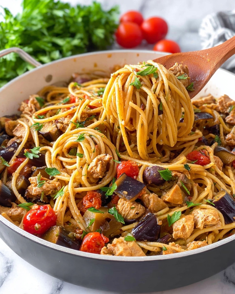 A white pan filled with a colorful pasta dish showing thick spaghetti noodles mixed with chunks of light brown cooked chicken, dark purple eggplant pieces, brown olives, and bright red cherry tomatoes cut in halves. The pasta is coated with a light sauce giving it a slight shine, and fresh green parsley leaves are scattered on top, adding a touch of freshness. A wooden spoon is sitting inside the pan, gently lifting a portion of the noodles. In the background, there are some whole red tomatoes and a bunch of green parsley visible against a white marbled surface. Photo taken with an iphone --ar 4:5 --v 7